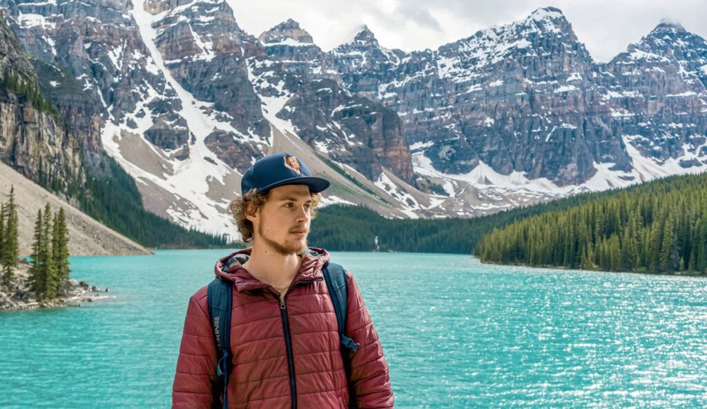 Backpacker steht vor einem See in Kanada