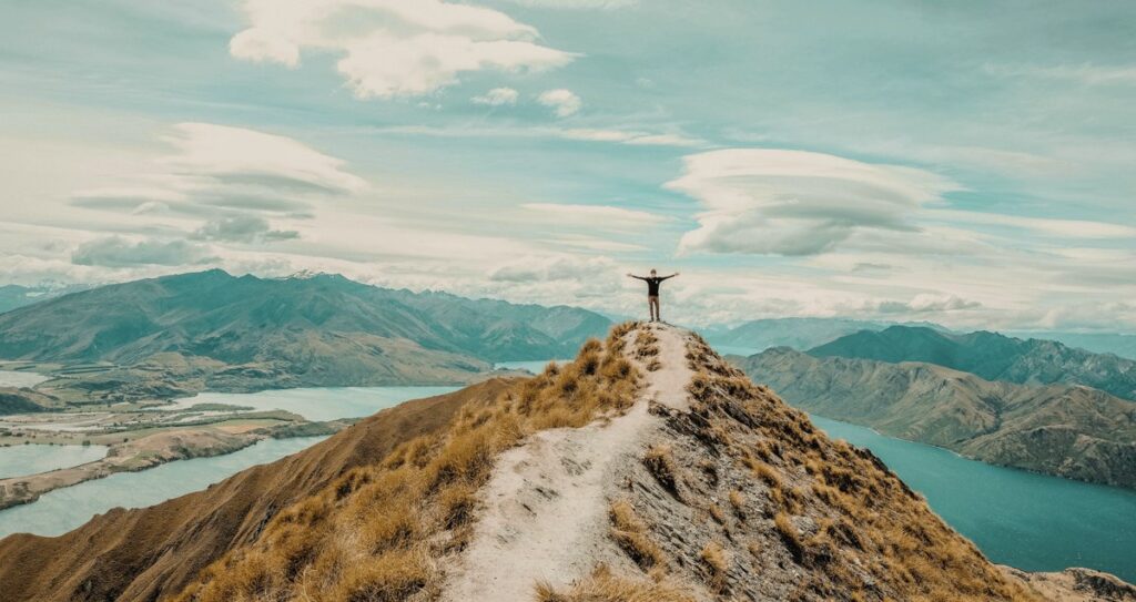 Backpacker steht auf einem Berg in Neuseeland