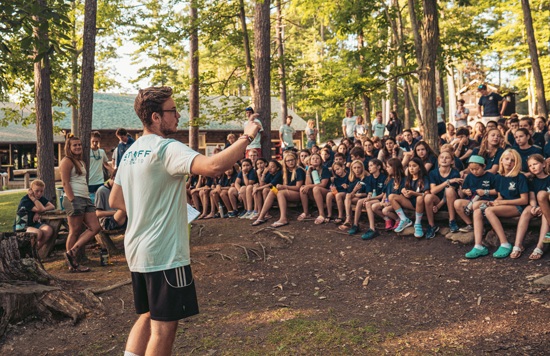 Mitarbeiter spricht im Sommercamp zu den Kindern