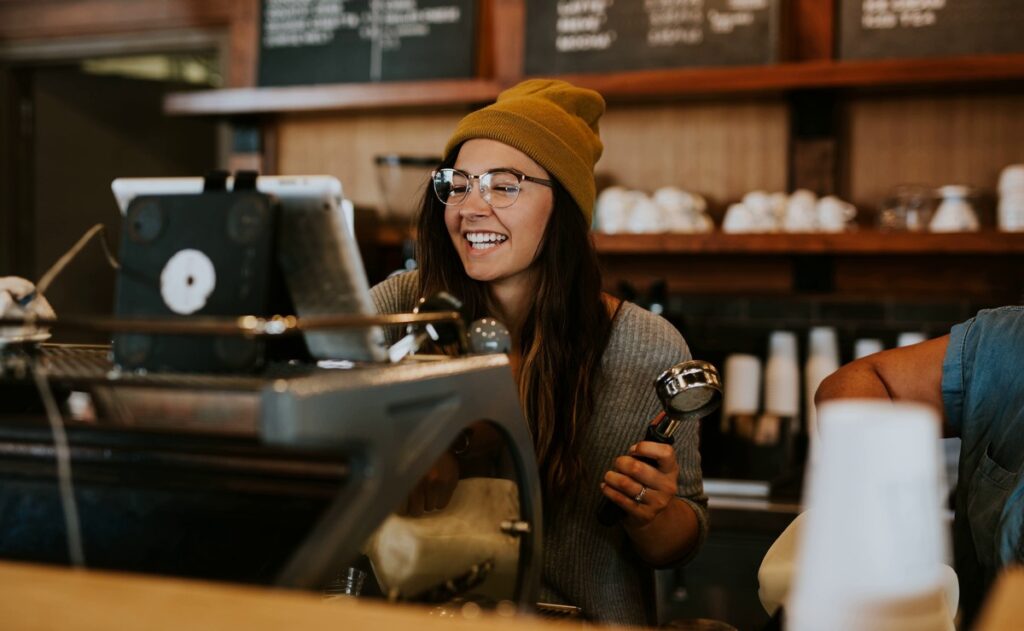 Backpacker arbeitet als Barista in einem Cafe